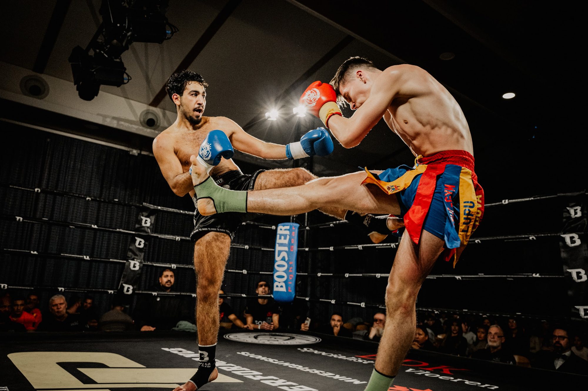 Zwei Kämpfer im Ring, einer setzt einen hohen Kick
