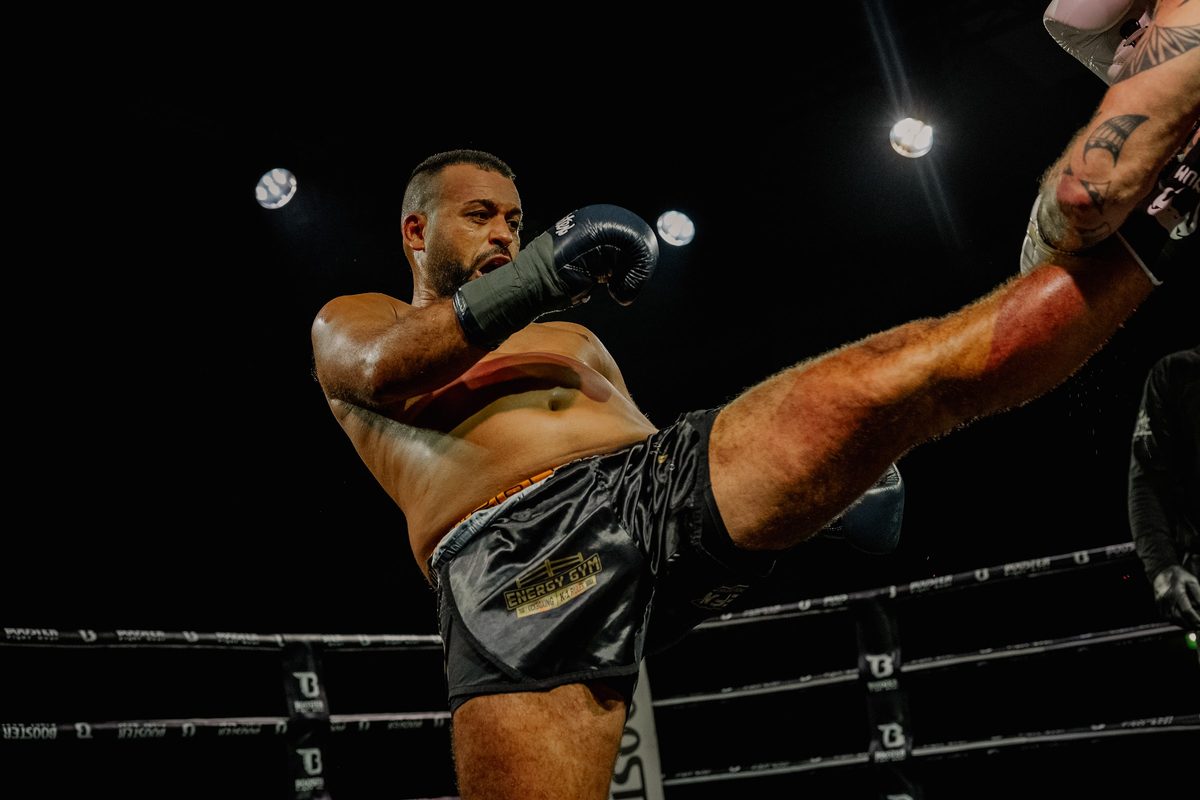 Sportler des Energy Gym bei einem hohen Kick im Ring